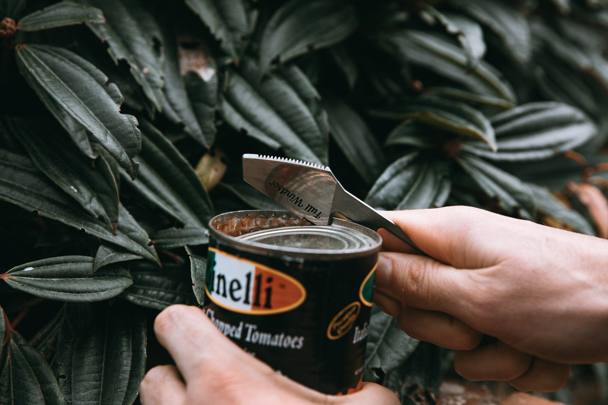 can opener on the full windsor muncher titanium multi utensil being used to open can